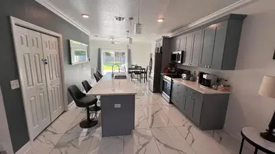a kitchen with gray cabinets and a table and chairs at Luxe Fort Lauderdale in Fort Lauderdale