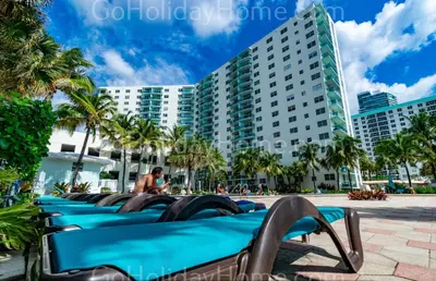 a row of blue benches in front of a building at The Tides apartment Go Holiday Home 5th floor in Hollywood