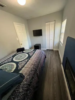 a bedroom with a bed and a flat screen tv at “La Casita” Beautiful home in the heart of Miami ! in Miami