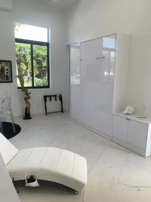 a white living room with a white couch and a glass door at Men only clothing option guesthouse near Wilton Manors in Fort Lauderdale