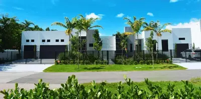a white building with palm trees in front of it at Men only clothing option guesthouse near Wilton Manors in Fort Lauderdale