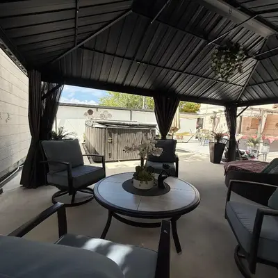 a patio with a table and chairs and an umbrella at Tiny place w private hot jacuzzi 7 min to Miami international airport in Miami