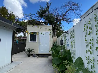 a backyard with a white fence and a garage at Tiny place w private hot jacuzzi 7 min to Miami international airport in Miami