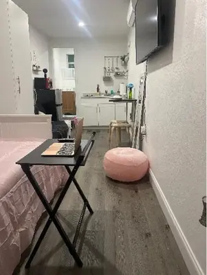 a living room with a table with a laptop on it at Tiny place w private hot jacuzzi 7 min to Miami international airport in Miami