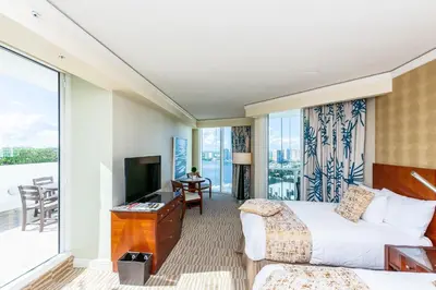 a hotel room with two beds and a balcony at TRUMP INTERNATIONAL BEACH RESORT 2 BEDROOM APARTMENT 1600 Sf Ocean and Bay View With Terrace in Miami Beach