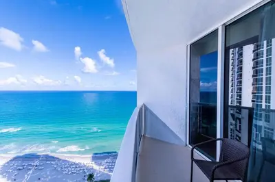 a balcony with a view of the ocean at TRUMP INTERNATIONAL BEACH RESORT 2 BEDROOM APARTMENT 1600 Sf Ocean and Bay View With Terrace in Miami Beach