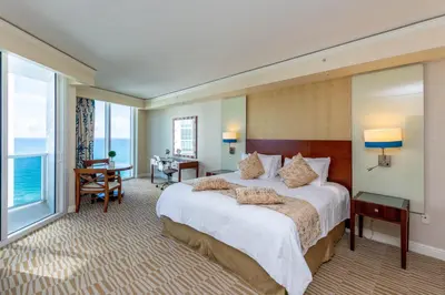 a hotel room with a large bed and a large window at TRUMP INTERNATIONAL BEACH RESORT 2 BEDROOM APARTMENT 1600 Sf Ocean and Bay View With Terrace in Miami Beach