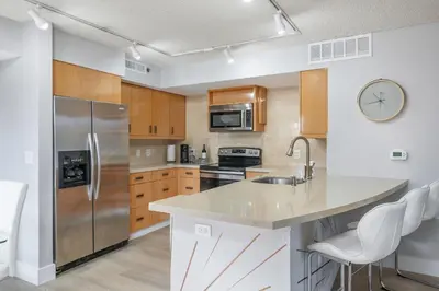 a kitchen with stainless steel appliances and wooden cabinets at Spacious 3 Bedroom Condo in Aventura in Aventura