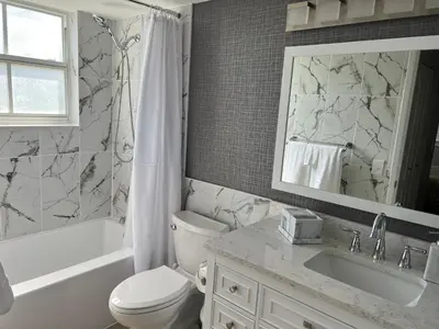 a bathroom with a toilet and a sink and a mirror at Spacious 3 Bedroom Condo in Aventura in Aventura