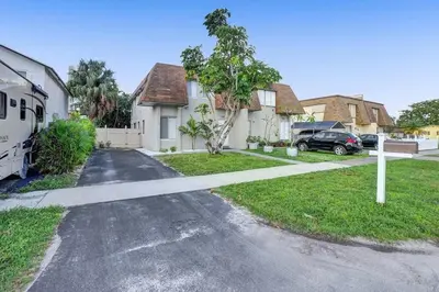 a house with a car parked next to a driveway at By Hard Rock Guitar Hotel casino 7 min walk in Dania Beach