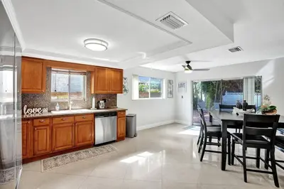 a kitchen with wooden cabinets and a table with chairs at By Hard Rock Guitar Hotel casino 7 min walk in Dania Beach
