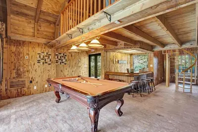 a pool table in a room with wooden walls at Family villa w heated pool gameroom fire pit in Davie