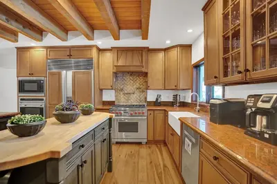 a large kitchen with wooden cabinets and wooden counters at Family villa w heated pool gameroom fire pit in Davie