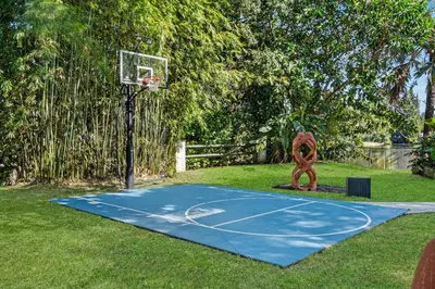a basketball hoop in a yard with a basketball net at Family villa w heated pool gameroom fire pit in Davie