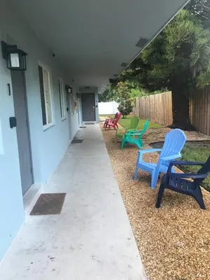 a patio with two blue chairs on a house at The Guesthouse 1 - Wilton Manors in Fort Lauderdale
