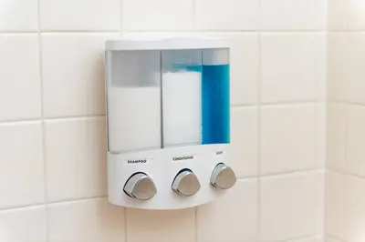 a soap dispenser on a white tiled bathroom wall at The Guesthouse 1 - Wilton Manors in Fort Lauderdale