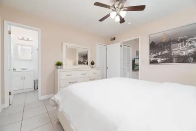 a white bedroom with a white bed and a ceiling fan at The Retreat 2 - Wilton Manors in Fort Lauderdale