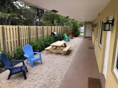 a patio with chairs and a picnic table and a fence at The Retreat 2 - Wilton Manors in Fort Lauderdale