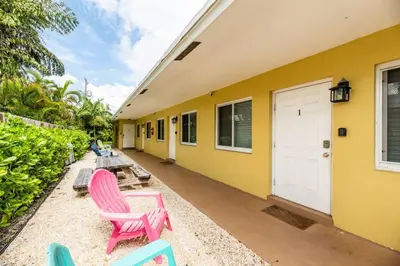 a group of pink chairs sitting outside of a building at The Retreat 2 - Wilton Manors in Fort Lauderdale