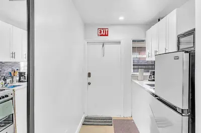 a white kitchen with a exit sign on the wall at Hollywood Beach Boutique Vacation Studio LB4 in Hollywood