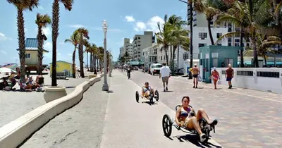 a couple of people riding in wheelbarrows on a beach at Hollywood Beach Boutique Vacation Studio LB4 in Hollywood