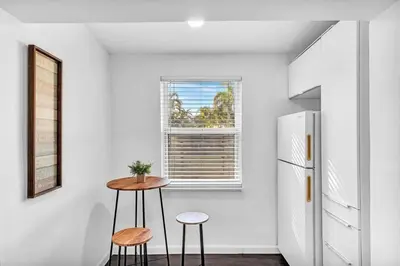 a kitchen with a table and two stools and a refrigerator at Hollywood 2 Bdrm Beach Vacation & Hard Rock Sc02 in Hollywood