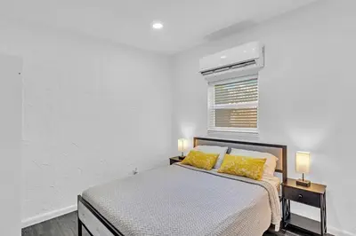 a bedroom with a bed with yellow pillows and a window at Hollywood 2 Bdrm Beach Vacation & Hard Rock Sc02 in Hollywood