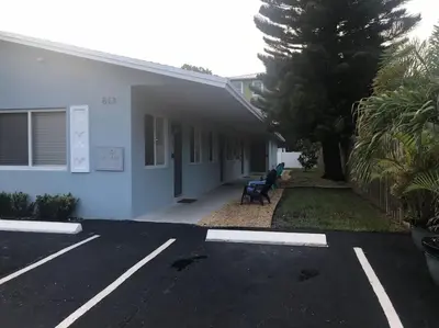 a parking lot in front of a white building at The Guesthouse 2 - Wilton Manors in Fort Lauderdale