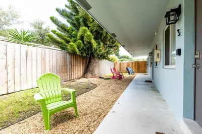 a yard with two green chairs and a fence at The Guesthouse 2 - Wilton Manors in Fort Lauderdale