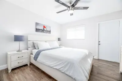 a white bedroom with a bed and a ceiling fan at The Guesthouse 3 - Wilton Manors in Fort Lauderdale