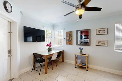 a dining room with a table and a ceiling fan at Pastel Dream in Hollywood