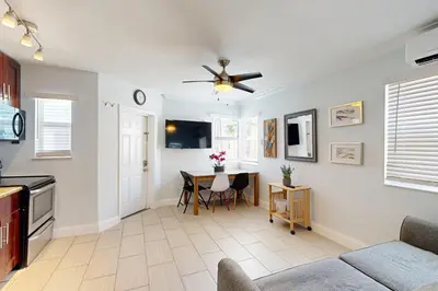 a living room with a table and a ceiling fan at Pastel Dream in Hollywood