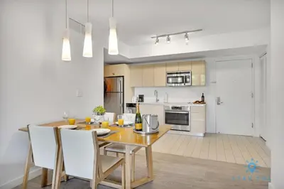 a kitchen and dining room with a wooden table and chairs at Modern Resort - Gym - Pool - Near Beach in Hallandale Beach