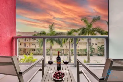 a table with two glasses of wine on a balcony at Modern Resort - Gym - Pool - Near Beach in Hallandale Beach