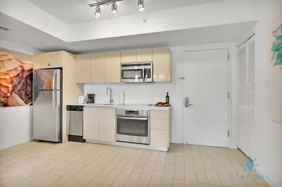 a kitchen with stainless steel appliances and a refrigerator at Modern Resort - Gym - Pool - Near Beach in Hallandale Beach