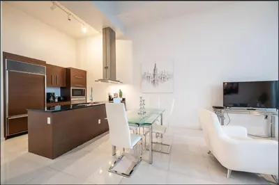 a kitchen and dining room with a table and chairs at Beautiful One Bedroom Condo 16ft ceilings at the W in Miami