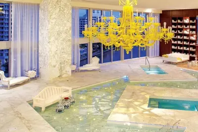 a hotel lobby with a pool and a chandelier at Beautiful One Bedroom Condo 16ft ceilings at the W in Miami