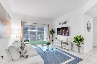 a living room with a white couch and a glass table at Lovely Unit Mins from Wynwood with Free Parking in Miami