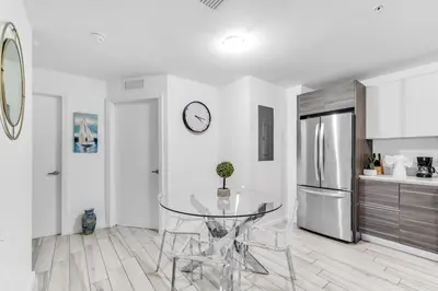 a kitchen with a glass table and a refrigerator at Lovely Unit Mins from Wynwood with Free Parking in Miami