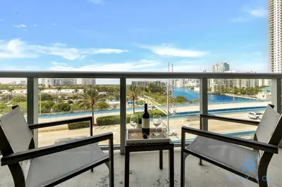 a balcony with two chairs and a table with a bottle of wine at Modern Resort - Balcony - Gym - Amazing Pool in Hallandale Beach