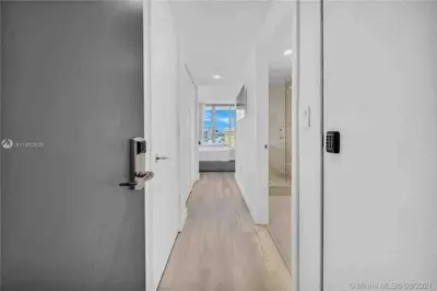 a hallway with white walls and a wooden floor at Relax by the Sea in This Cozy Beachfront Room 908B in Hallandale Beach
