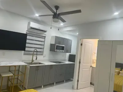 a kitchen with a ceiling fan and a stove top oven at Stunning Deluxe Studio in Hialeah