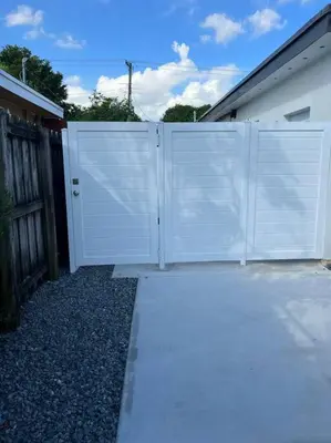 a white fence on the side of a house at Stunning Deluxe Studio in Hialeah