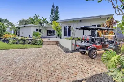 a golf cart parked in front of a house at Brand New! Heated Pool, Golf Cart, Next to Beach in Fort Lauderdale