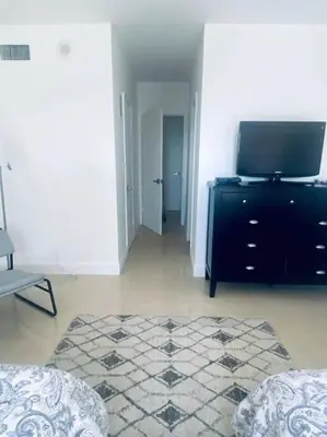a living room with a tv and a black dresser at Ocean Reserve Piso 9 - STR 2412 in Miami Beach