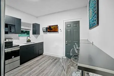 a kitchen with black and white cabinets and a door at River House 4BR, Pool/Hot Tub in Miami