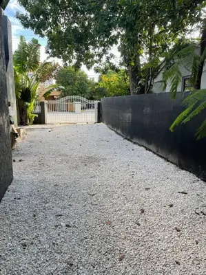 a gravel driveway with a fence and a house at River House 4BR, Pool/Hot Tub in Miami