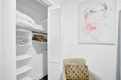 a walk in closet with a chair and a painting at River House 4BR, Pool/Hot Tub in Miami