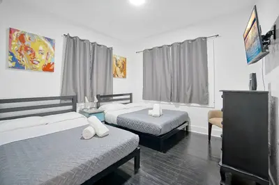 a hotel room with two beds and a tv at River House 4BR, Pool/Hot Tub in Miami