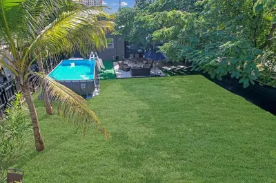 a yard with a swimming pool and a palm tree at River House 4BR, Pool/Hot Tub in Miami